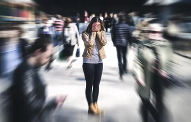 Fotobehang Panic attack in public place. Woman having panic disorder in city. Psychology, solitude, fear or mental health problems concept. Depressed sad person surrounded by people walking in busy street. © terovesalainen