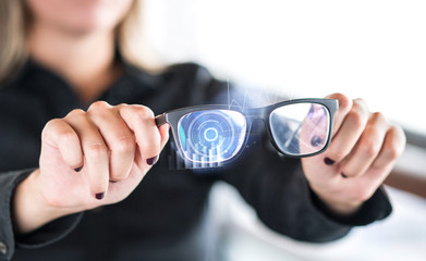 Person holding nanotech smart glasses. Eyewear with interactive augmented reality (AR) interface and screen with visual digital sensor. Futuristic cyber and nano technology. Modern nanotechnology.