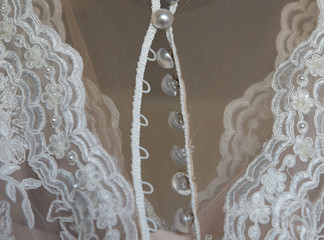 close up on ripped wedding dress and hair in buttons