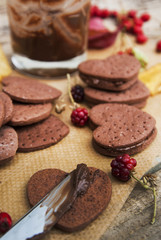 Delicious heart shape homemade chocolate cookies on rustic wooden background. Sweet chocolate dessert or snack.