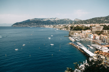 Fototapeta na wymiar Views of the city of Sorrento in Italy, panorama and top view. Night and day, the streets and the coast. Beautiful landscape and brick roofs. Architecture and monuments of antiquity. Shops and street