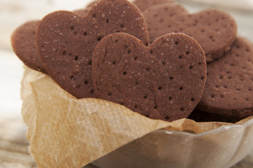 Delicious heart shape homemade chocolate cookies on rustic wooden background. Sweet chocolate dessert or snack.