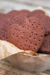 Delicious heart shape homemade chocolate cookies on rustic wooden background. Sweet chocolate dessert or snack.