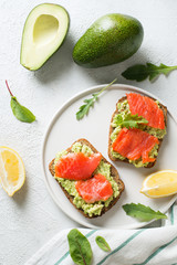 Toasts with avocado and salmon on plate