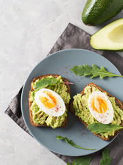 Avocado toasts with eggs and salad on breakfast