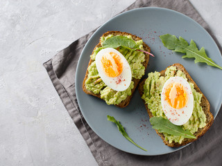 Avocado toasts with eggs and salad on breakfast