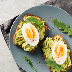 Avocado toasts with eggs and salad on breakfast