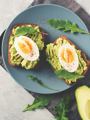 Avocado toasts with eggs and salad on breakfast