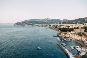Fototapeta na wymiar Views of the city of Sorrento in Italy, panorama and top view. Night and day, the streets and the coast. Beautiful landscape and brick roofs. Architecture and monuments of antiquity. Shops and street