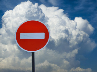 road sign entry is prohibited on the background of the sky with clouds