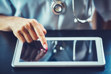 Doctor working on a digital tablet with copy space