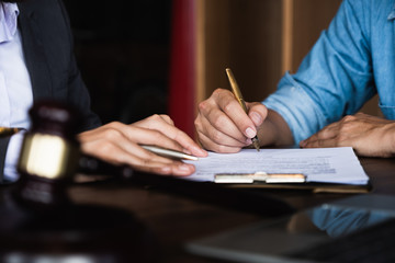 Close up of an executive hands holding a pen and indicating where to sign a contract at office