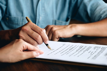 Business man signing a contract. Close up of two business partners signing a document for agreement...