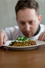 Chef checking up spaghetti before serve.
