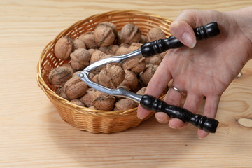 Woman cracking walnuts over a wooden table 