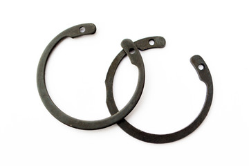 Black circlip retaining rings scattered on a white background