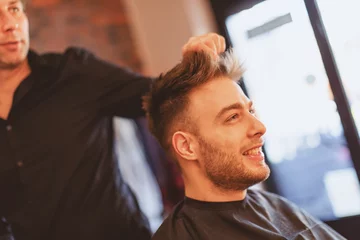Crédence de cuisine en verre imprimé Salon de coiffure Handsome man at the hairdresser getting a new haircut