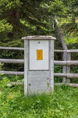 Stromanschlusskasten mit einem gelben Schild und Blitz Symbol