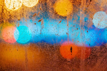 Dirty glass close up on the background of colorful night bokeh
