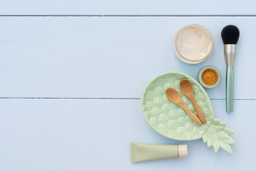 Beauty background with facial cosmetic products on blue wooden background with copy space