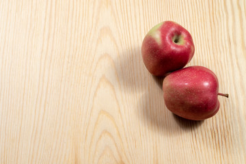 Two ripe apples on a wooden table 