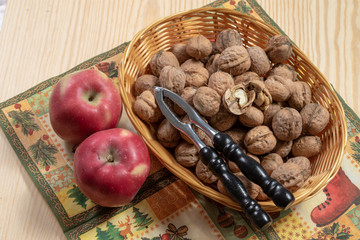 Ripe apples beside a basket full of walnuts