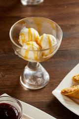 Glass bowl of ice-cream on wooden table