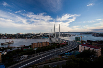 Golden cable-stayed bridge road car traffic from above. Modern Vladivostok Russia night illumination. Old and modern central buildings.	