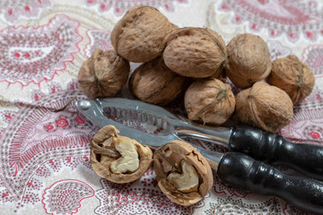 Halfed walnut beside nutcracker and walnuts