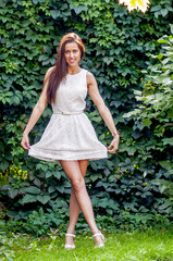 Young girl in a white dress in a summer park
