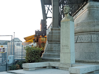 Fototapeta na wymiar A bust of Gustav Eiffel in the rays of the setting sun set at the Eiffel Tower in Paris, France.