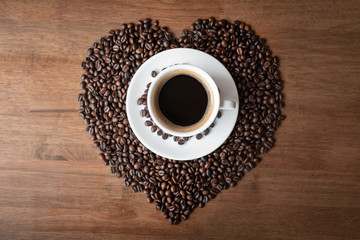 Hot coffee cup with heart pattern of roasted coffee beans