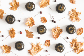 Autumn composition. Black pumpkins, golden leaves on white background. Autumn, fall, halloween concept. Flat lay, top view