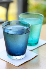 Cold water in a blue  transparent glass.