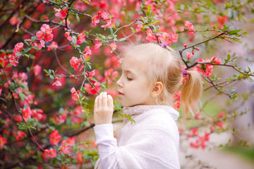 Nice blonde girl near the blossom tree