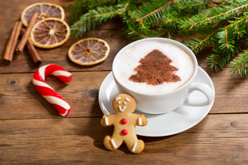  Cup of cappuccino coffee with christmas tree drawing and gingerbread cookie