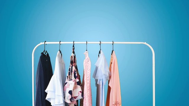 Women's clothing on a white clothes hanger on blue pastel background.