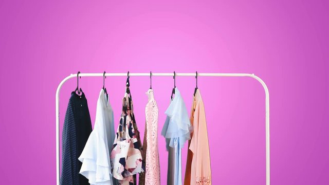 Women's clothing on a white clothes hanger on violet pastel background.