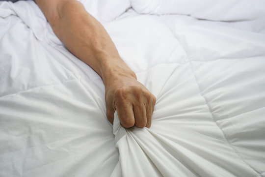 hand of men pulling white sheets in ecstasy, orgasm.