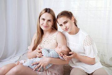 Mother and children newborn and older sister. Happy family with children at home. Love, trust and tenderness concept.