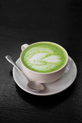 Green tea latte in white cup.