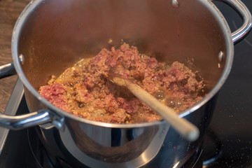 Big silver pot full of fresh mince meat in the kitchen 