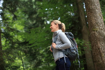 Junge Frau beim Wandern glücklich im Wald