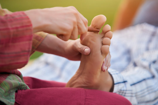 Deep relaxing feet massage. Cropped shot of foot reflexology. Foot close up.