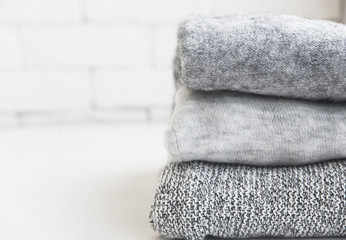 A pile of gray sweaters and an empty seat