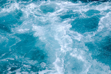 Troubled blue sea water with white foam, abstract nature background concept