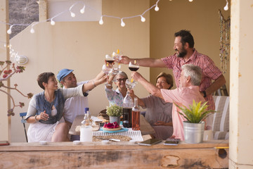 happy group of different ages people celebrating and having fun together in friendship at home or...