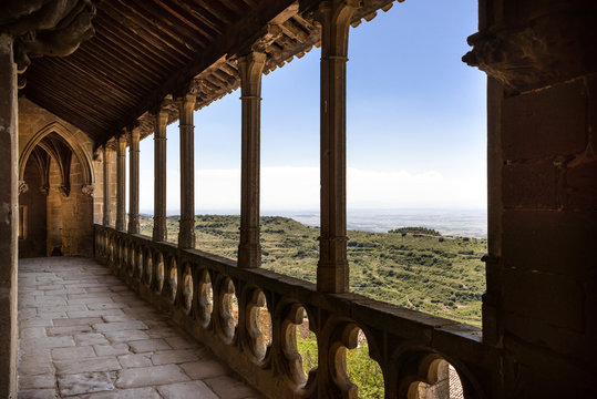 Spain, Navarre, Ujue: Detail view of famous church of Santa Mar&iacute;a in the city center of old small Spanish village with panoramic view over green landscape and blue sky - concept travel history