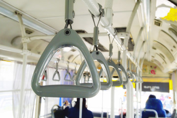Row of Gray handle on ceiling for Standing passenger on the bus. Selective focus of Hand grip strap on public bus.