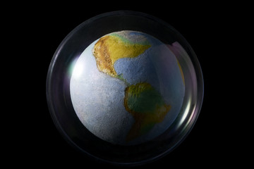 Earth enclosed in a plastic bubble. Global warming and pollution concept . Isolated on black...